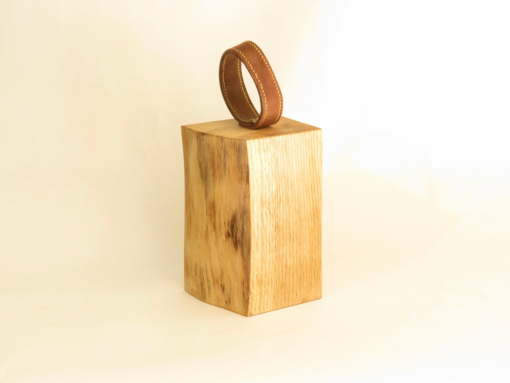 Sustainably sourced oak door stop with handmade brown leather handle